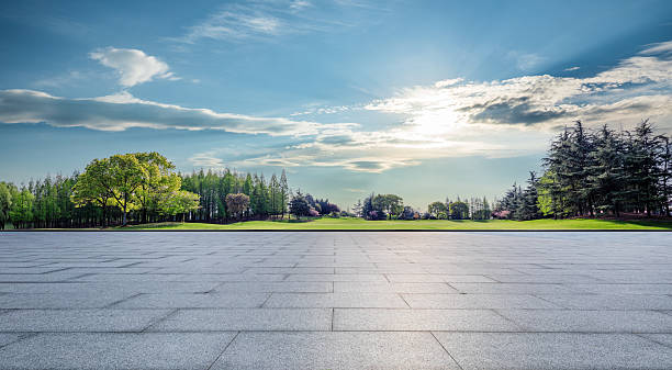 istock Empty square floor and green grass with forest natural landscape under blue sky 2215501230