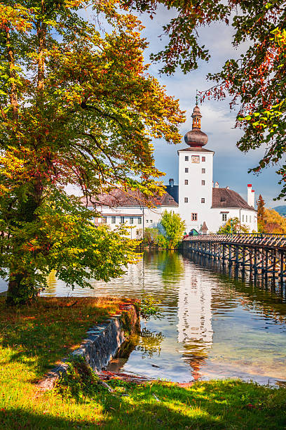 istock Ort, Austria surrounded by autumn-colored trees, reflects on Traunsee water. 2215506381