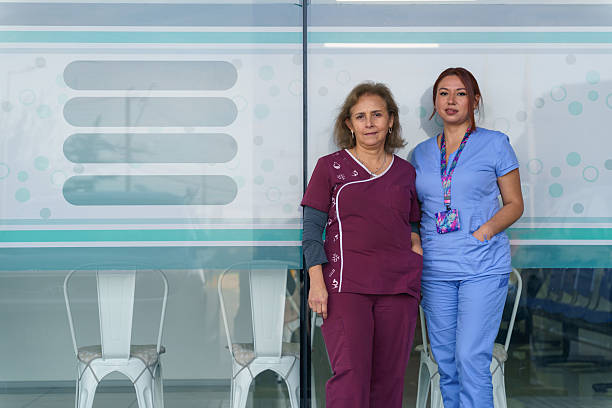 Two latin american nurses posing outside of their medical center