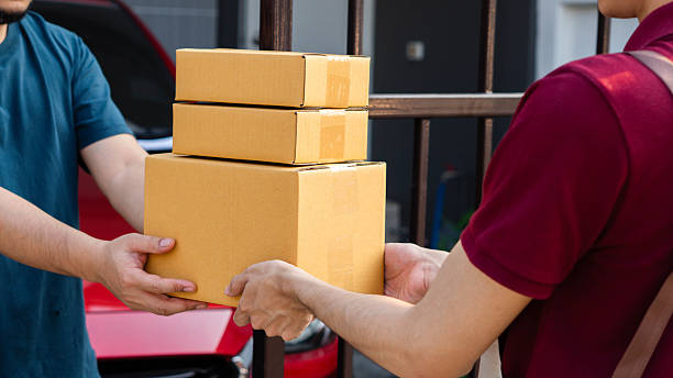 istock Service and delivery concept. Delivery man holding an empty parcel box The courier delivers the item urgently. Online store, postman, delivery service, parcel delivery with good depth of field 2215511288
