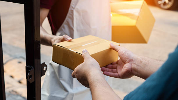 istock Service and delivery concept. Delivery man holding an empty parcel box The courier delivers the item urgently. Online store, postman, delivery service, parcel delivery with good depth of field 2215511289