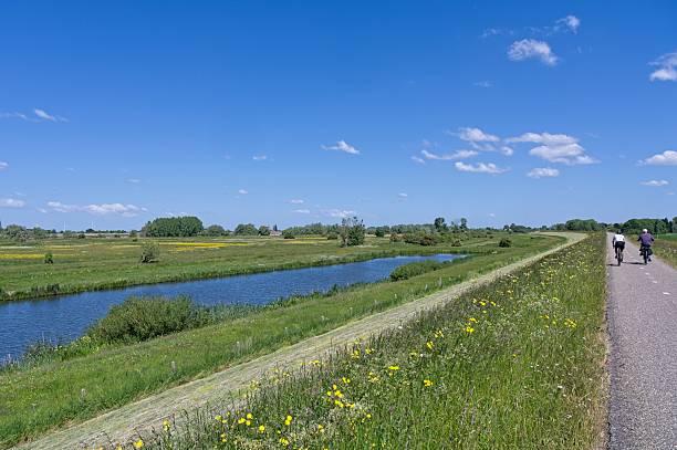 istock Two cyclists cycle on a dike along the Waal river 2215512690