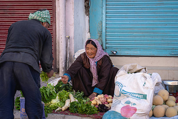 Leh, India - September 12, 2024: A vegetable vendor serves a customer in the historic city centre
