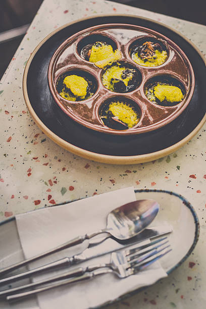 istock Escargot De bourgogne Burgundy snails in garlic herb butter on a table 2215514619