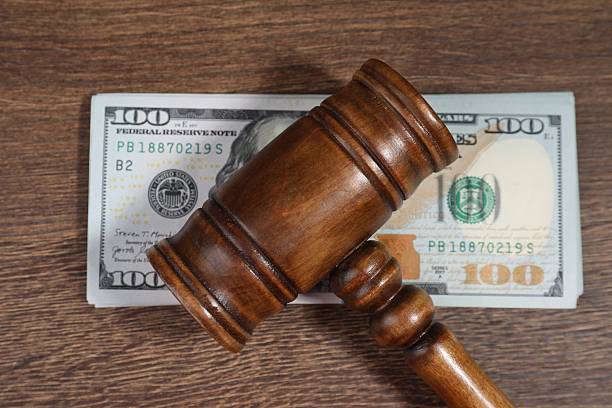 istock Alimony. Gavel and dollar banknotes on wooden table, top view 2215514920