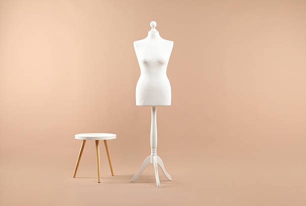 istock Female mannequin and stool on beige background 2215515685