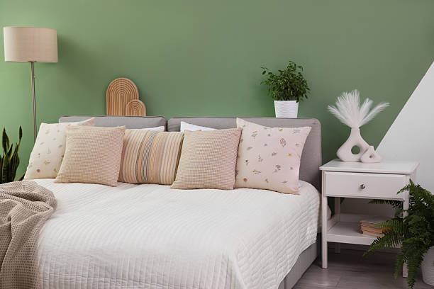 istock Stylish bedroom interior with large bed, houseplants and decorative elements 2215515837
