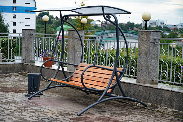 istock Outdoor swing bench with canopy on a tiled patio. 2215521304