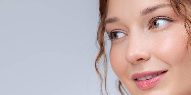 istock Closeup of Smiling Woman Looking Aside With Soft Glowing Skin 2215523708