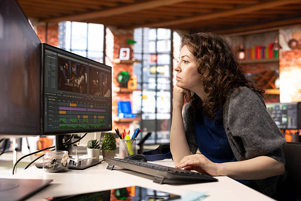 Female filmmaker editing montage and video clips with creative software Female filmmaker editing montage and video clips with creative software, creating media content in post production. Agency workspace features movie making modern tools, cinematic industry. female film editor stock pictures, royalty-free photos & images
