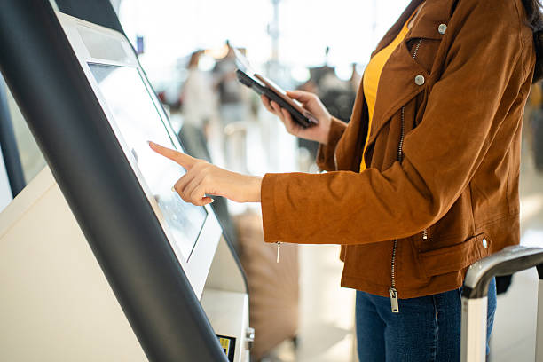 istock Close up the woman hands touching the screen while self check in kiosk technology machine getting boarding pass at the airport terminal 2215527214