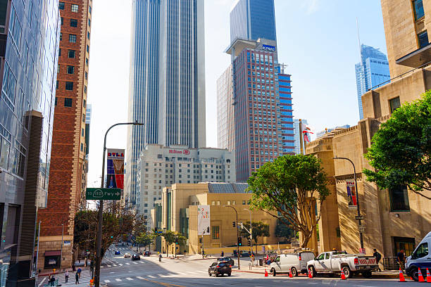 Los Angeles, California - December 4, 2024: Vibrant city scene showing the Los Angeles Central Library, Hilton Hotel, and KPMG offices with busy traffic and pedestrians in the foreground.