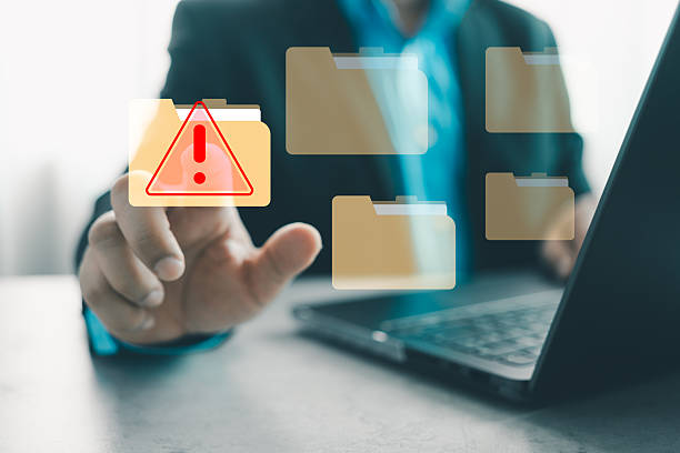 Hand interacting with a cybersecurity alert symbol. Virus and spyware, malicious software, malware, or cyberattacks on computer networks. Cybersecurity alert with digital file folder.