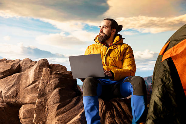 istock Young explorer keeps working at the top of the mountain with internet everywhere 2215537013