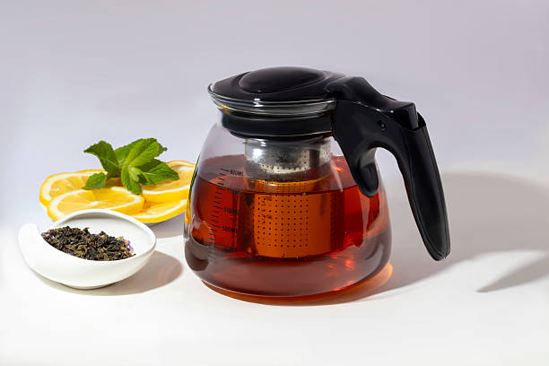 istock Glass teapot with metal strainer inside. Kitchen utensils on gray background. 2215542318