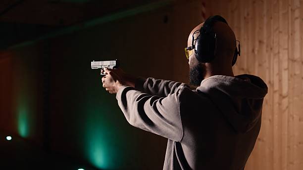 istock Man shooting targets with pistol, learning to operate handgun in close quarters 2215544784
