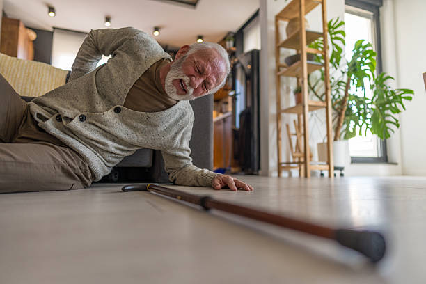 Senior Man Experiencing Fall at Home Reaching Out in Pain