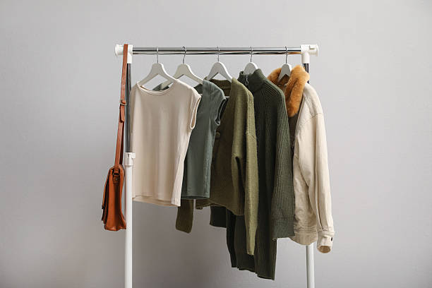 istock Rack with clothes and bag near light wall 2215548525