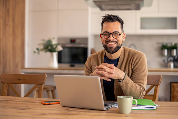 istock Man in Glasses Working on Laptop in Bright Kitchen with Modern Decor 2215548651