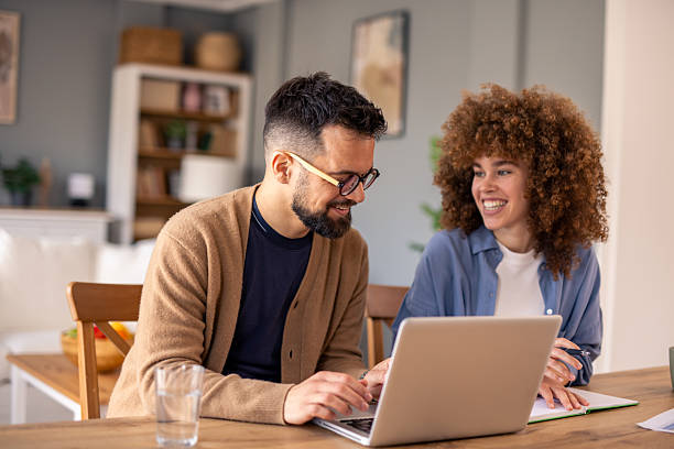 istock Young Professional Couple Working Together On Laptop In Modern Home Office Setting 2215548828
