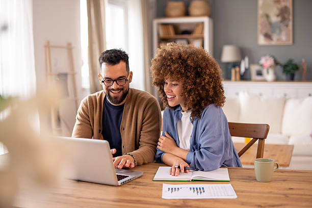 istock Young Professional Couple Working Together On Laptop In Bright Modern Home Office Setting 2215548849