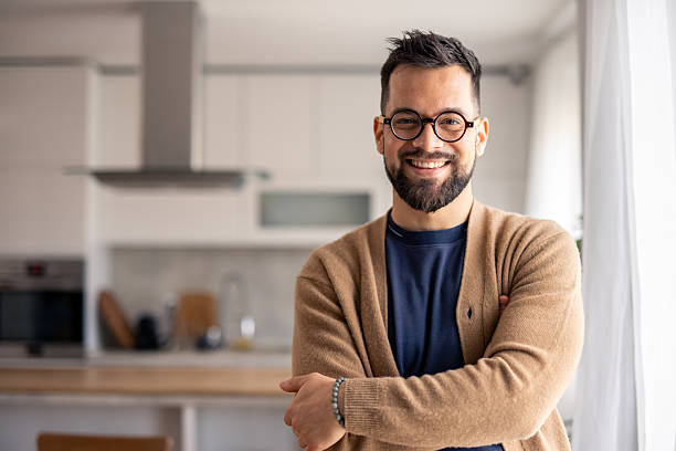 istock Smiling Man With Glasses in Beige Cardigan in a Bright Modern Home Kitchen 2215548879