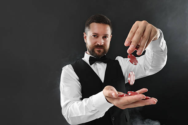 istock Croupier holding casino chips on black background with smoke 2215549133