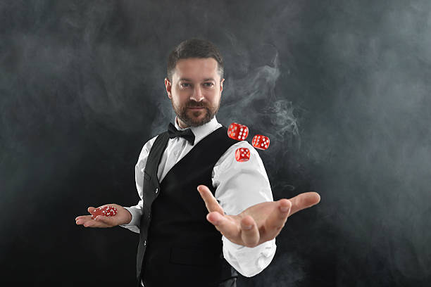 istock Professional croupier holding dice and casino chips on black background with smoke 2215549139