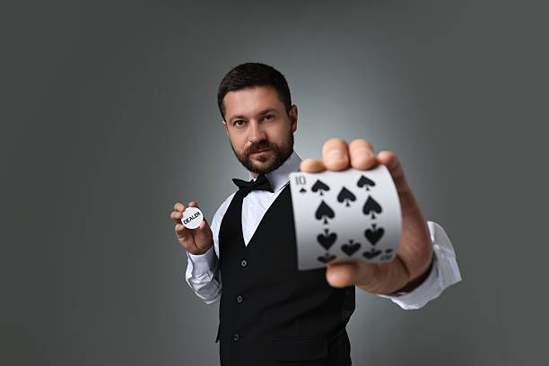 istock Croupier holding card and dealer button on grey background 2215549149