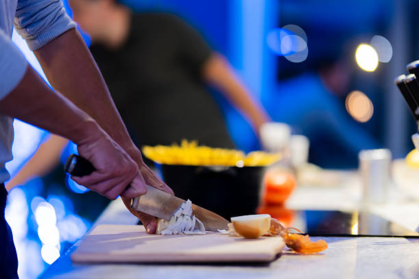 Hands preparing ingredients on a cutting board in a brightly lit kitchen environment, depicting the cooking process.