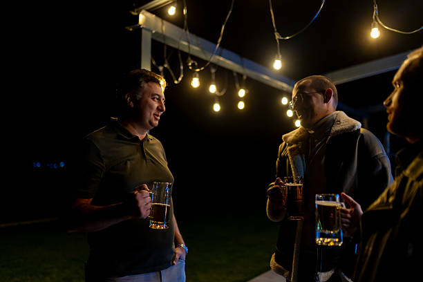 istock Group of three friends enjoying drinks outdoors in a cozy evening setting 2215551651