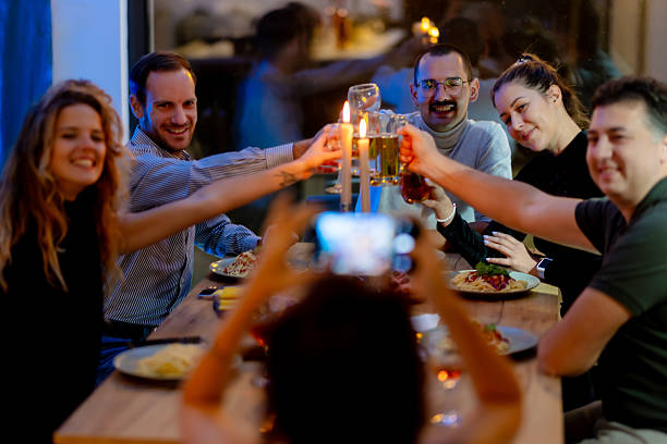 A joyful group of friends raising glasses in a toast during a cozy dinner, emphasizing friendship, celebration, and togetherness in a relaxed and comforting atmosphere.