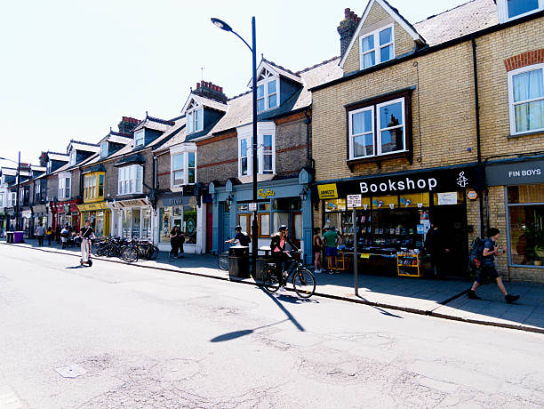 Cambridge, Cambridgeshire / United Kingdom - May 11th 2025: Cyclists, traffic, and pedestrians on Mill Road in Cambridge
