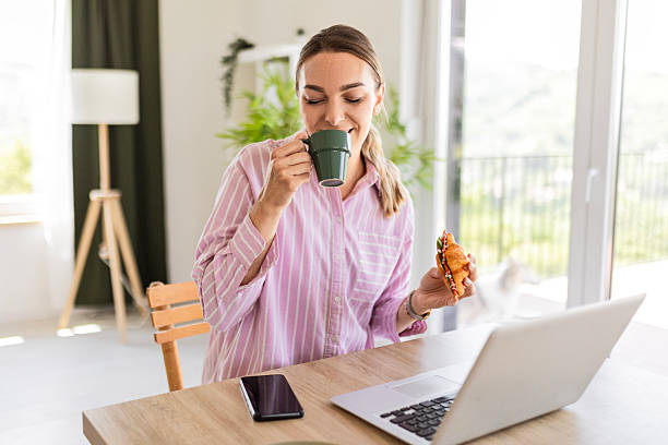 istock Woman Balancing Work and Snack at Home 2215555291