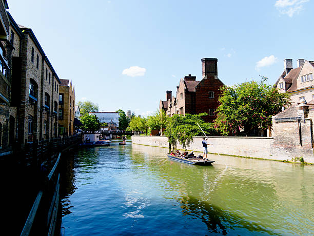 Cambridge, Cambridgeshire / United Kingdom - May 11th 2025: Tourists punting in Quayside, courtesy of Scudamore's Punting Company.