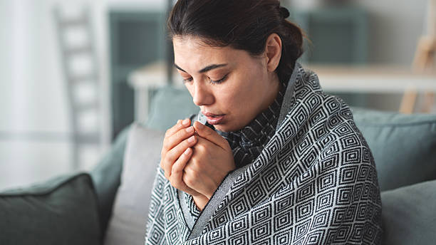 istock Woman sitting in cold room 2215555955