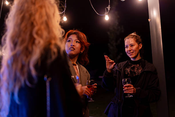 istock Group of friends enjoying nighttime conversation under string lights at a casual gathering 2215559475