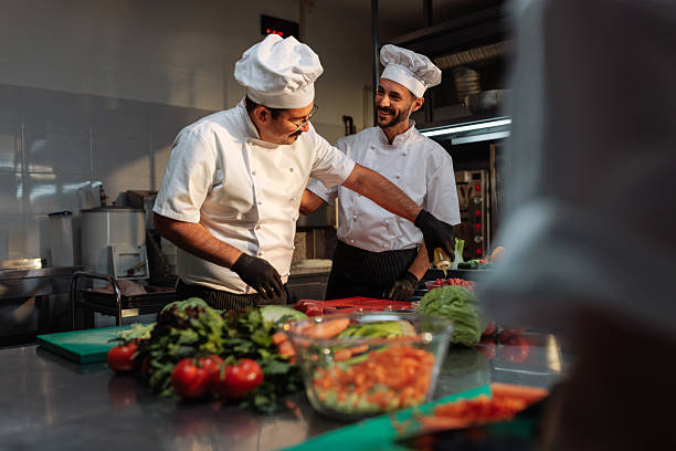 istock Two cheerful chefs preparing fresh vegetables in a restaurant kitchen 2215560408