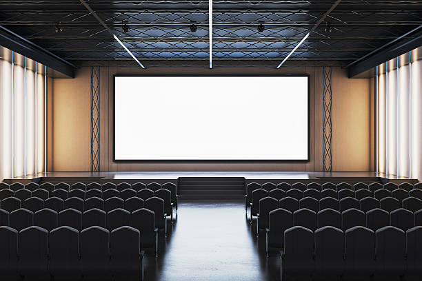 istock Empty modern conference hall with large blank screen and black chairs arranged in rows for corporate presentation or business event setup. 3D Rendering 2215568540