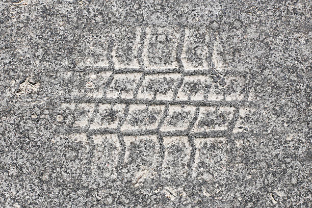 Worn out urban surface. Vehicle mark on gritty road. Grunge grained background from city street.