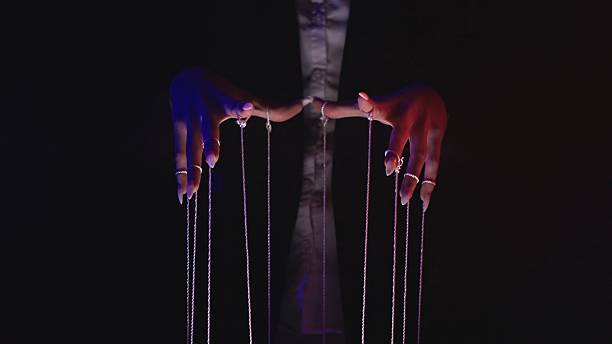istock Manipulation and Control through Puppetry Strings in Darkness 2215572120
