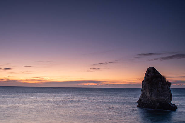 Atmospheric pre-sunrise view of Futatsushima sea stack rising from the Pacific off Isohara Coast, Kitaibaraki City, Ibaraki Prefecture, Japan. Long-exposure winter scene with silky water and pastel sky—perfect for travel, wellness or inspirational designs.