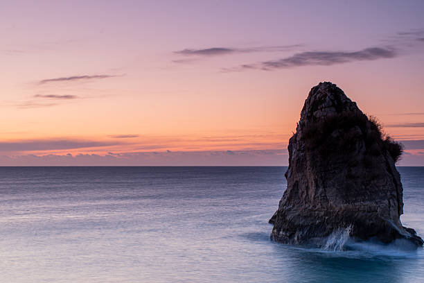 Rock formation in sea at sunrise