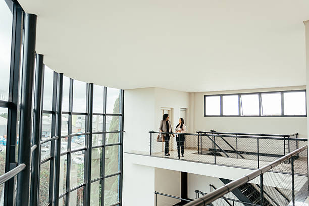 istock Businesswomen talking in a large modern room, robust architecture 2215576618