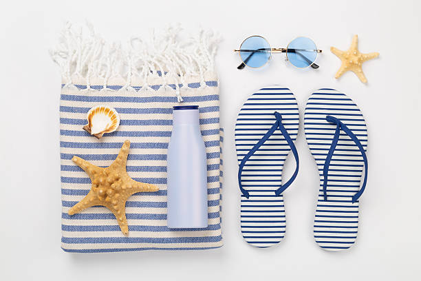 istock Beach towel with summer accessories on color background, top view 2215577170