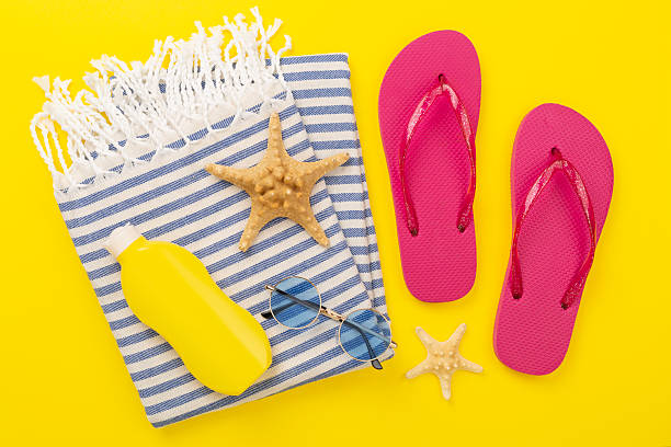 istock Beach towel with summer accessories on color background, top view 2215577171