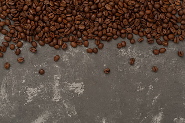 istock Roasted coffee beans with leaves on concrete background,top view 2215582448