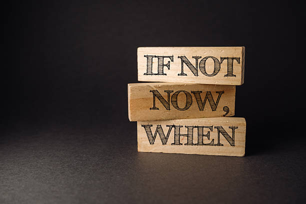 istock Three wooden blocks with the words if not now when written on them 2215588343