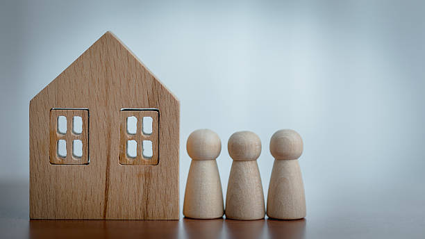 istock Wooden House Model and Figurines on a Table with Blurred Background 2215589187