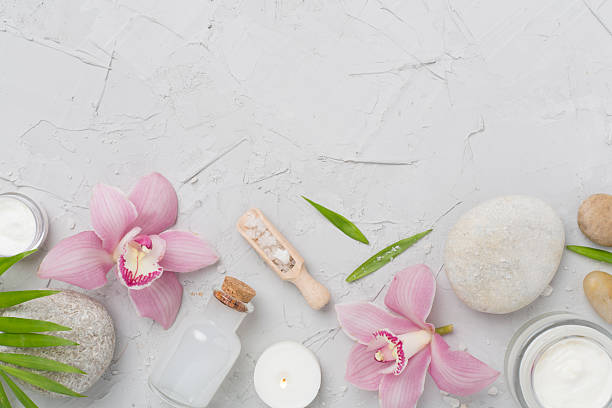 istock Composition with orchids and massage stones on concrete background, top view 2215589300